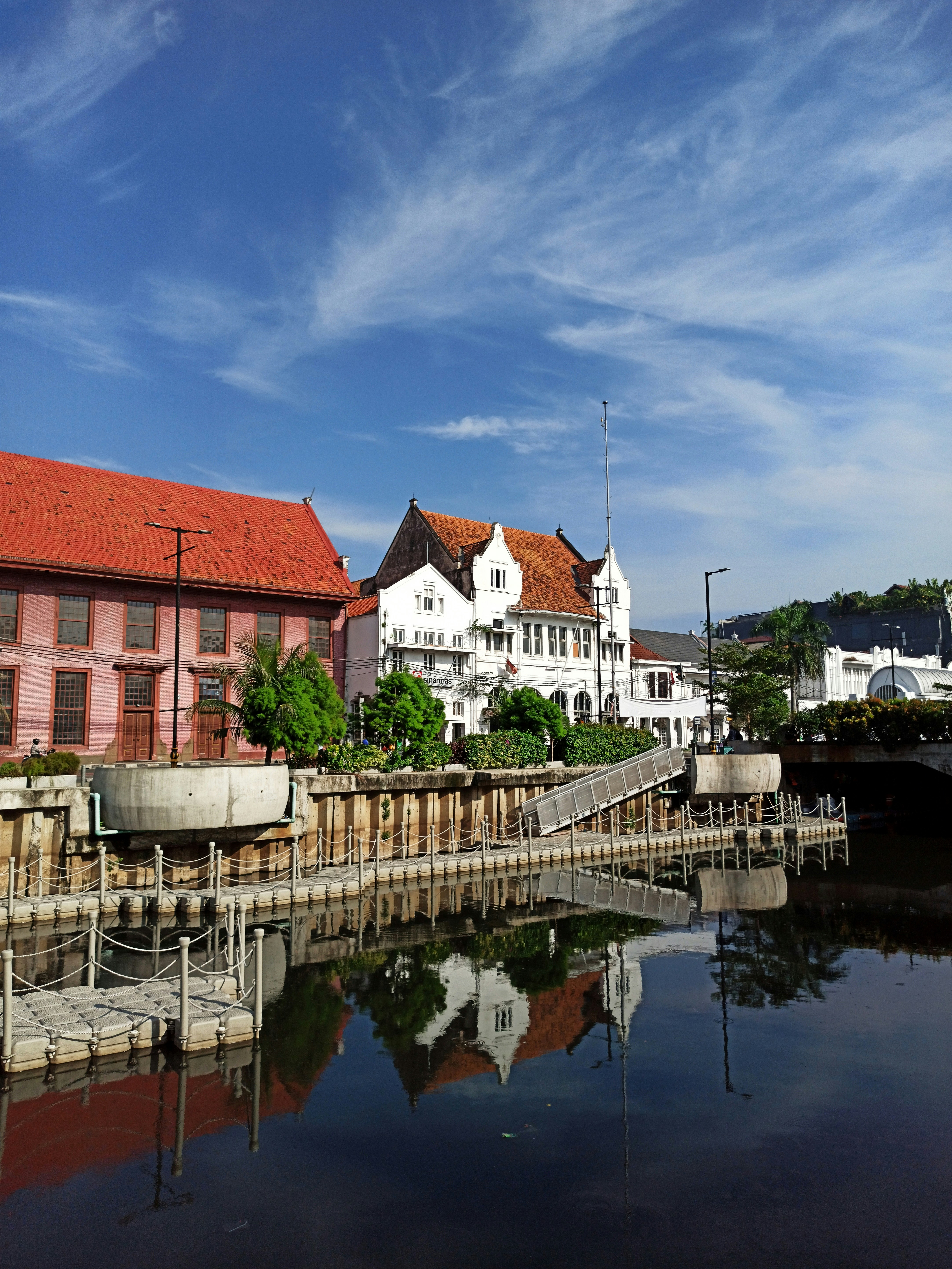 white and brown concrete building beside river under blue sky during daytime