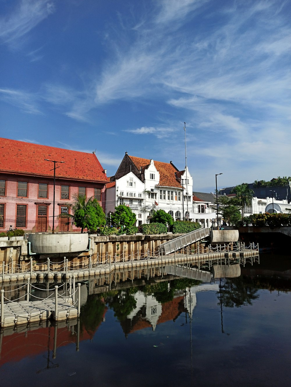 white and brown concrete building beside river under blue sky during daytime