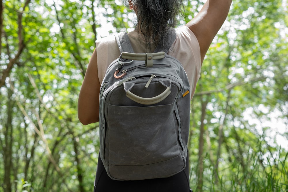 woman in gray t-shirt and black pants with brown backpack