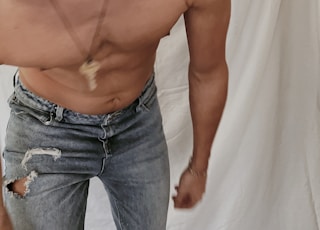 topless man in blue denim jeans