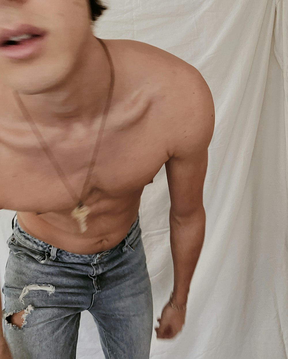 topless man in blue denim jeans