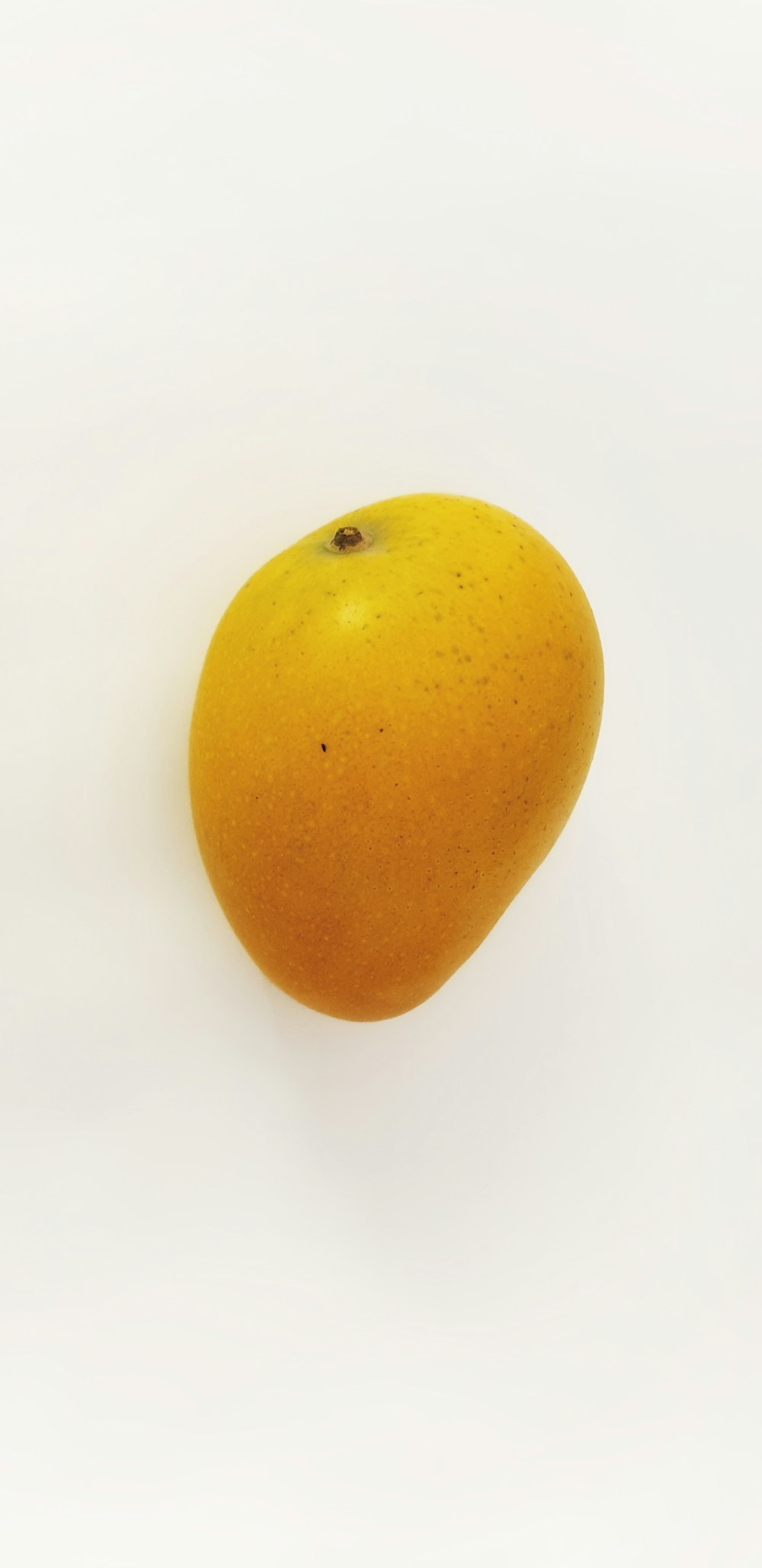 yellow round fruit on white surface