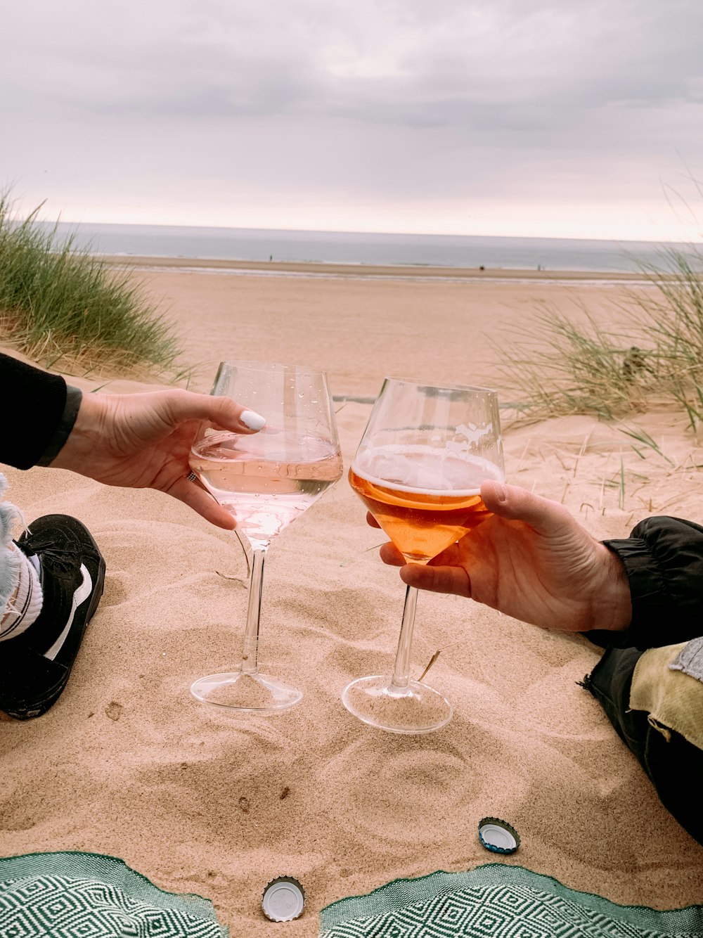 person holding clear wine glass with brown liquid