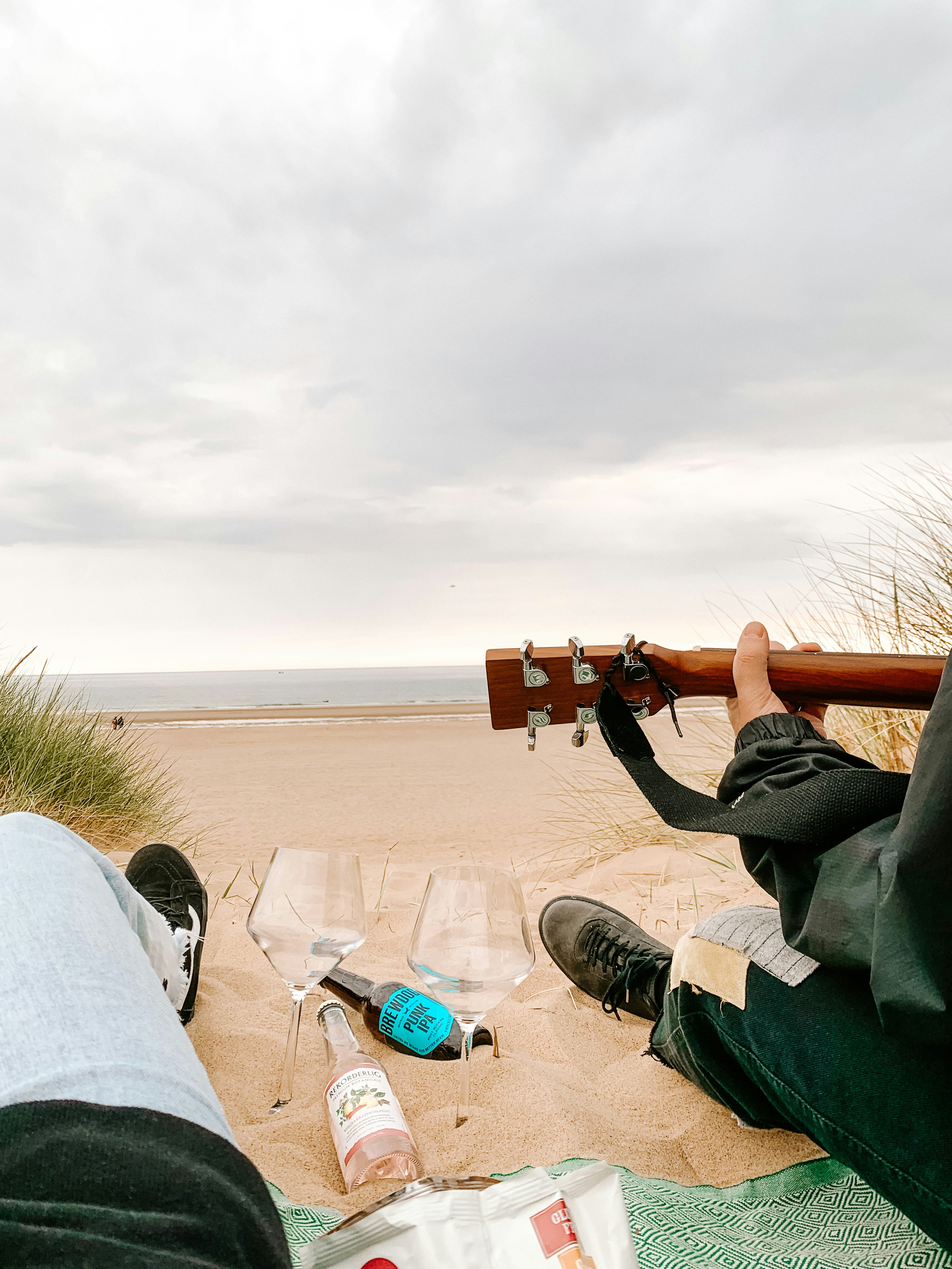 man in gray jacket taking photo of brown sand during daytime