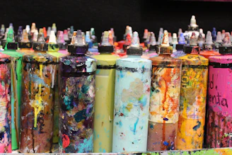 Bottles of various paint chemicals and solvents lined up in a warehouse.
