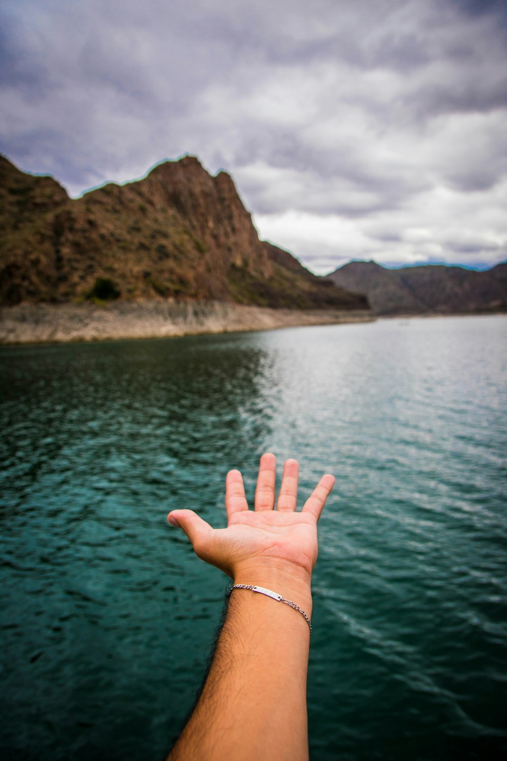 person with green manicure near body of water during daytime