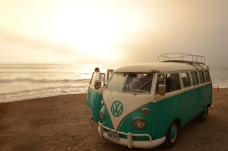A classic white van parked by the seaside with surfboards leaning against it, inviting a relaxed trip.