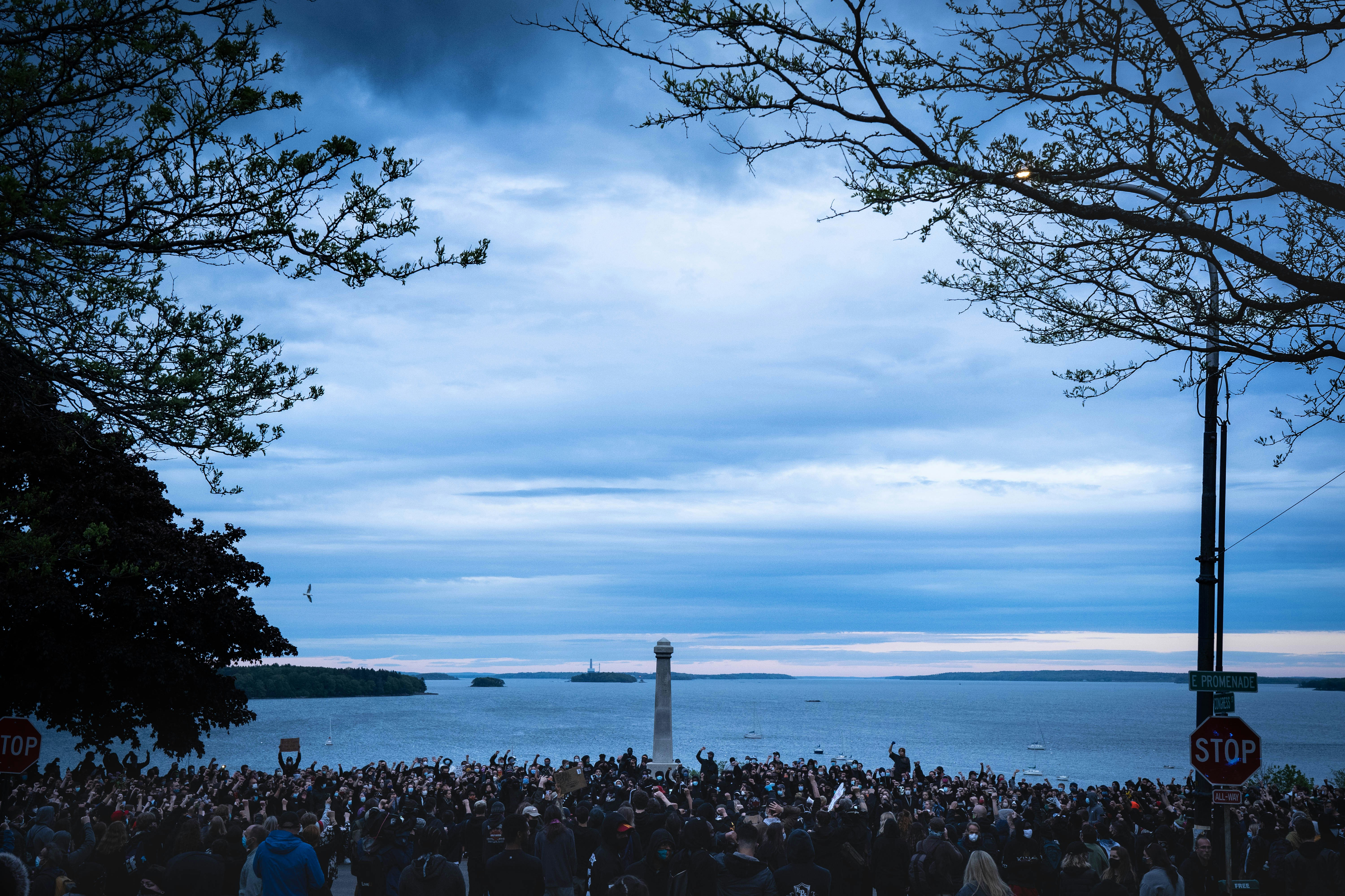 a crowd of people standing around a light house