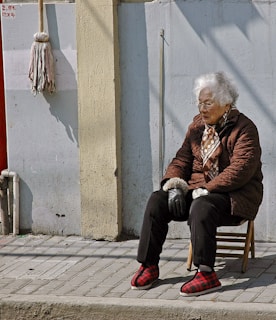 woman in brown jacket sitting on brown wooden chair