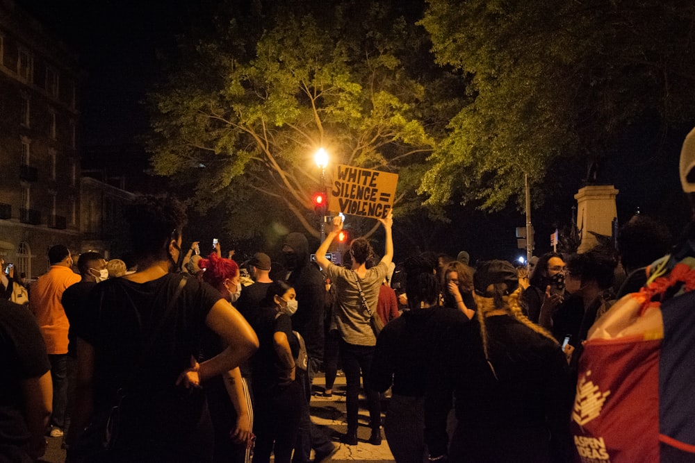 people standing and raising their hands during nighttime