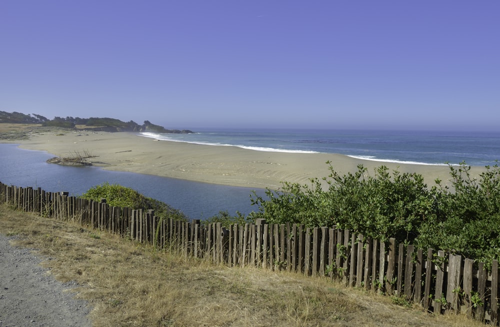 recinzione di legno marrone in riva al mare durante il giorno