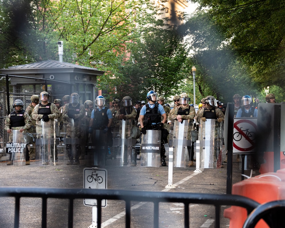 people standing near gray metal fence during daytime