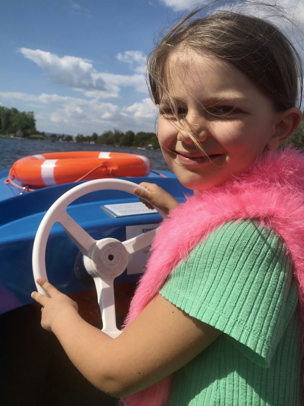 girl in pink wings riding on blue inflatable ring
