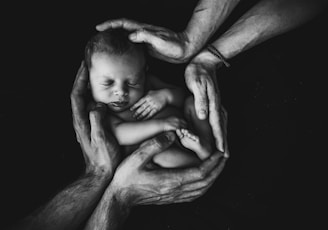 grayscale photo of woman hugging baby