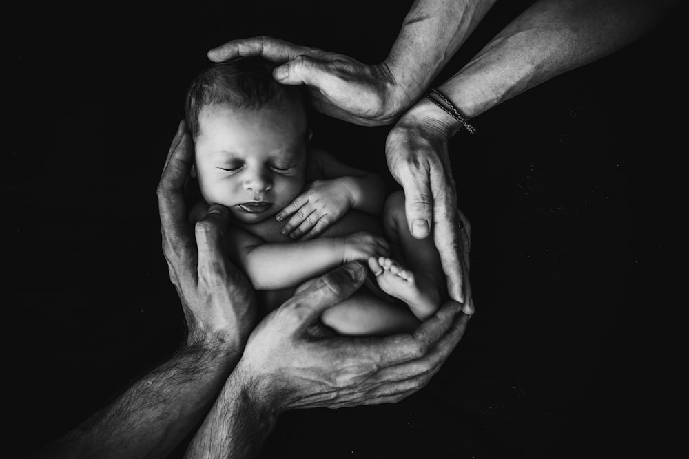 grayscale photo of woman hugging baby