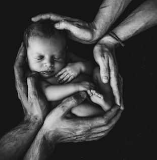 grayscale photo of woman hugging baby