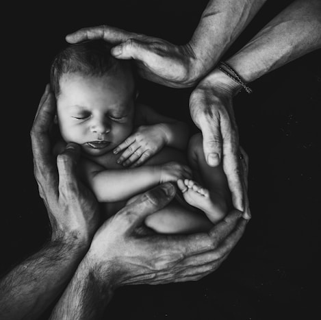 grayscale photo of woman hugging baby