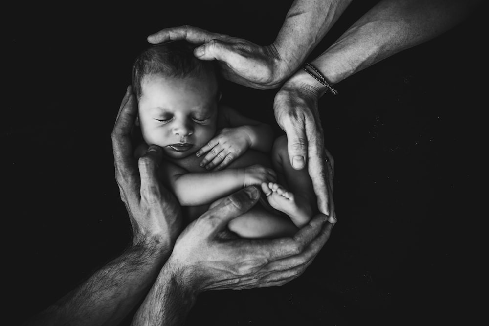 foto en escala de grises de una mujer abrazando a un bebé
