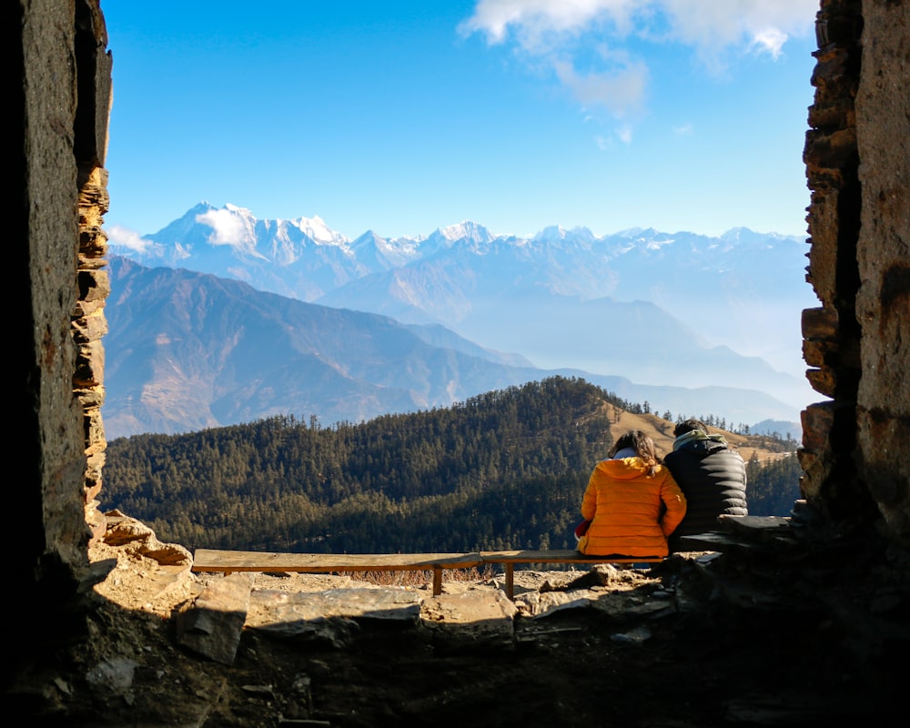 2 person sitting on rock formation during daytime