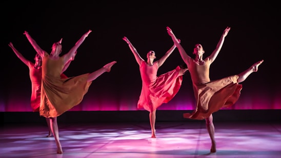 Graceful dancers moving in unison, bathed in soft royal purple and gold lighting, embodying worship through dance.