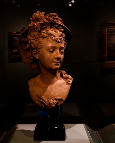 An artistic bust STL file featuring expressive facial details and textured hair, displayed on a pedestal.