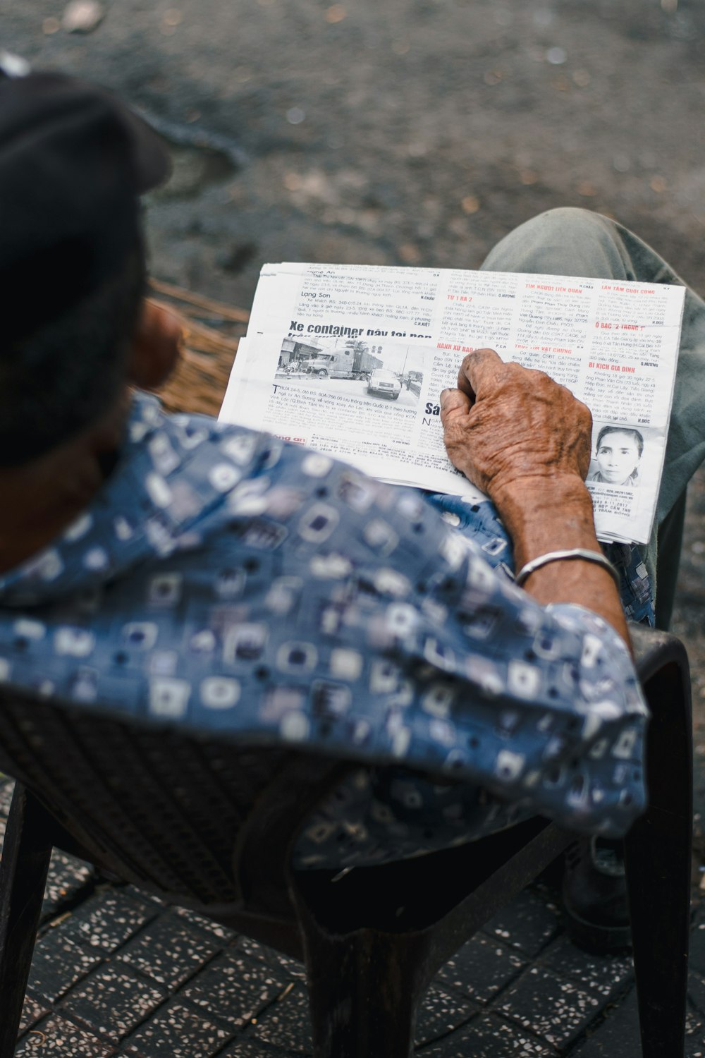 person in blue and white polka dot shirt holding white paper