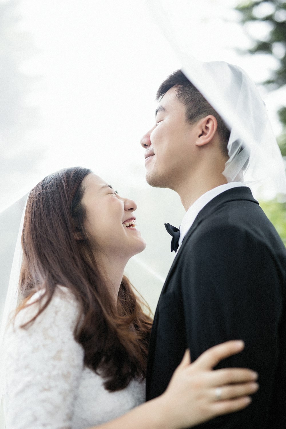 man in black suit jacket kissing woman in white wedding dress