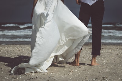 man and woman holding hands while walking on beach during daytime luck google meet background