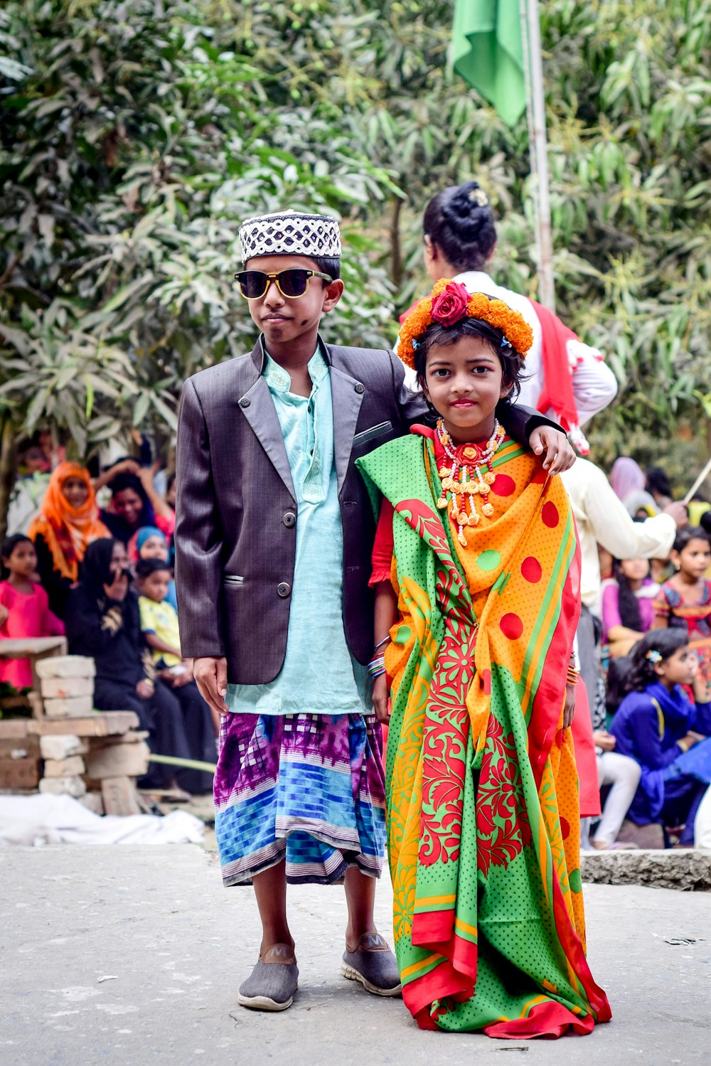 man in green suit jacket and woman in green and yellow sari dress