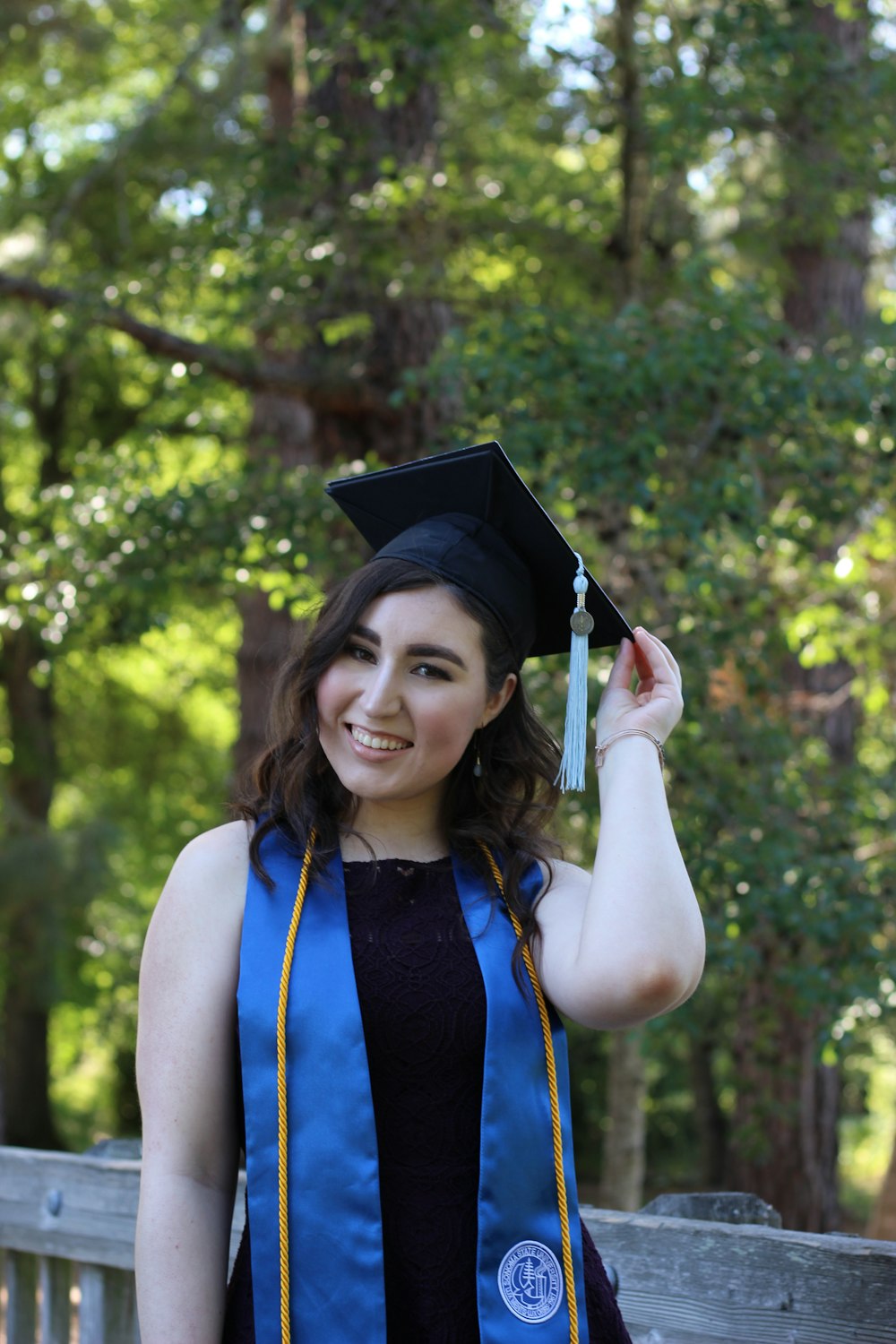 woman in blue and black academic dress smiling