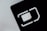An abstract close-up of a SIM card slot icon, featuring bold, geometric lines and shapes. The negative space is emphasized with a contrasting light gray background and dark, shadowed interior.