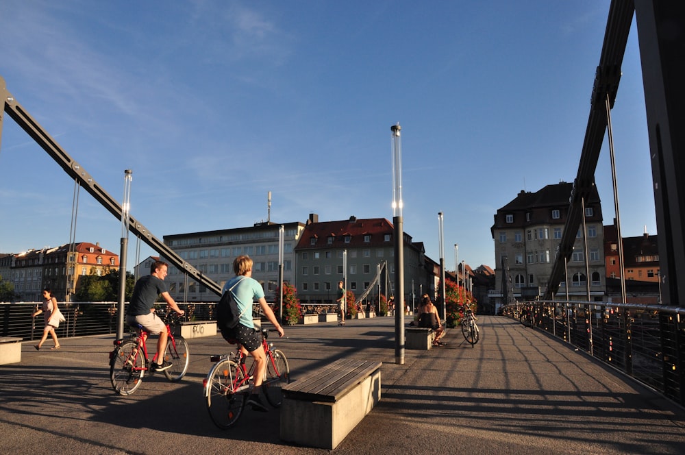 pessoas andando de bicicleta na ponte durante o dia