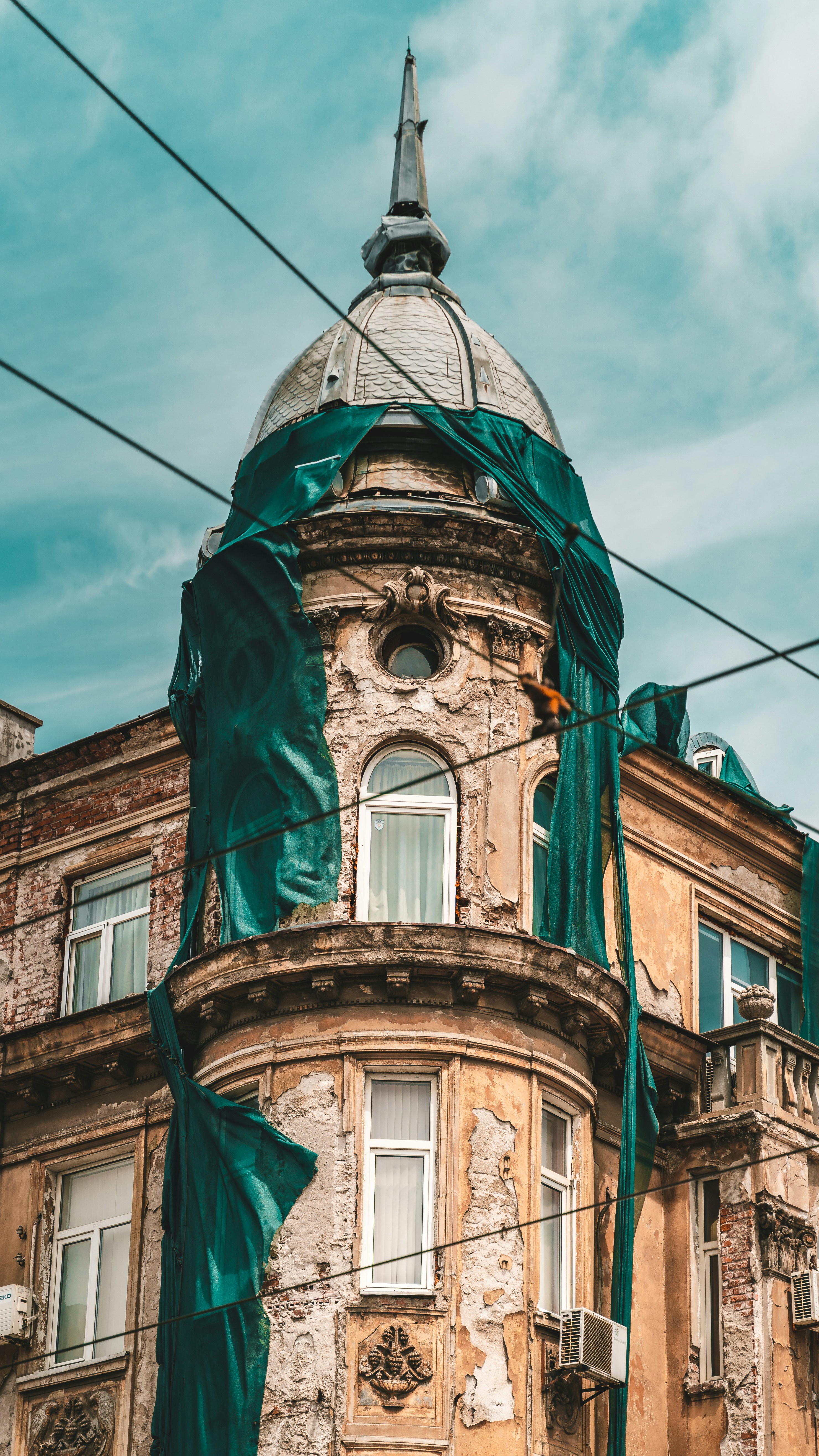 edifício de concreto marrom e verde sob o céu azul durante o dia