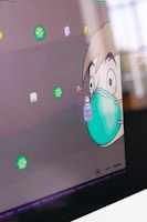 A cartoon character with wide eyes wearing a large teal mask, holding a bottle labeled 'Spray & Stay'. Surrounding the character are colorful illustrations of virus particles. The scene has a playful and educational vibe.