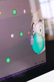 A cartoon character with wide eyes wearing a large teal mask, holding a bottle labeled 'Spray & Stay'. Surrounding the character are colorful illustrations of virus particles. The scene has a playful and educational vibe.