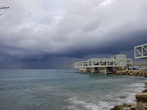 A striking photo of a modern marine research facility blending seamlessly with the ocean horizon under a clear sky.