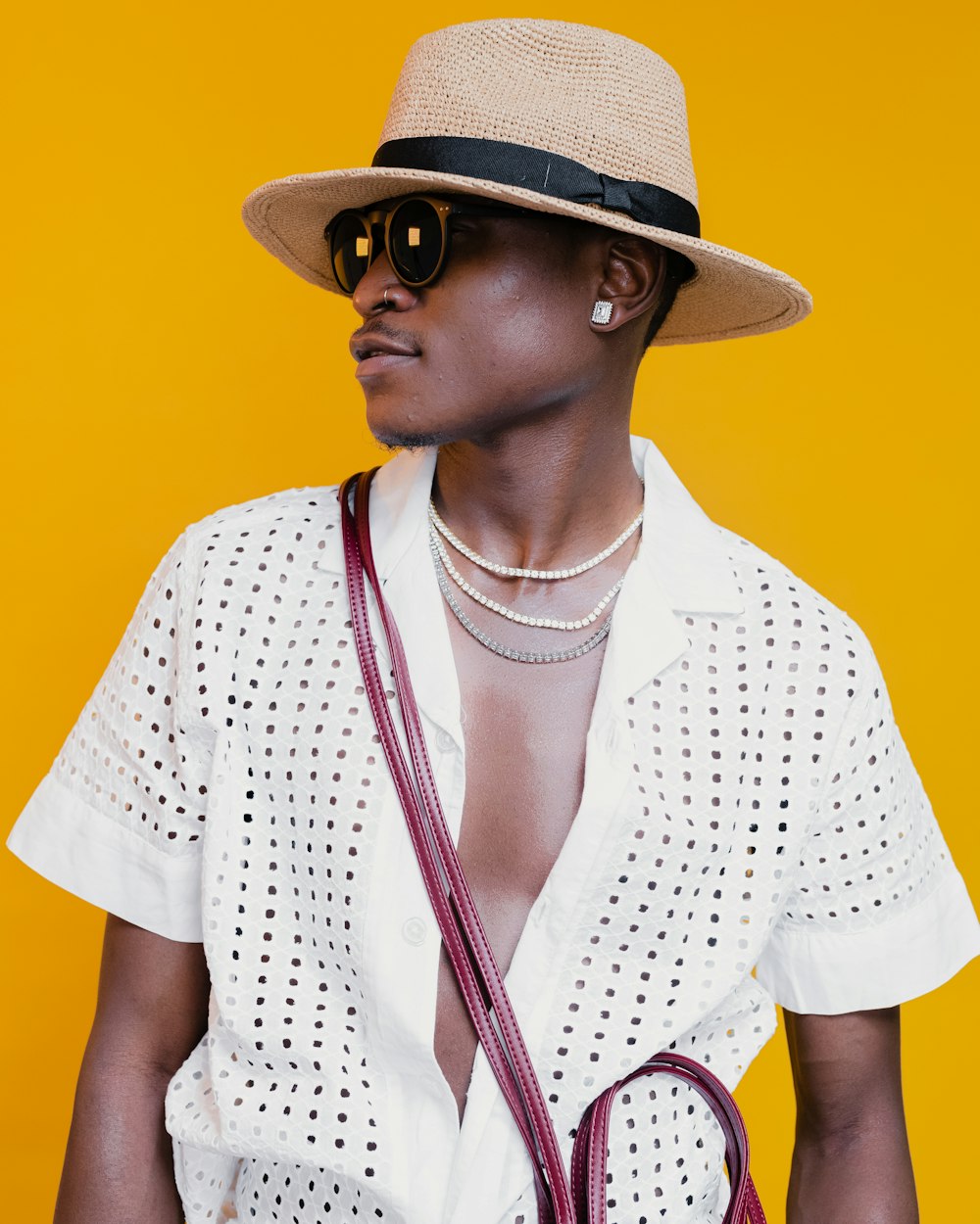 man in white and black polka dot button up shirt wearing brown fedora hat