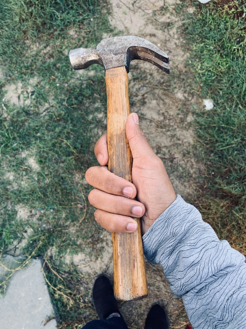 person holding brown wooden handle