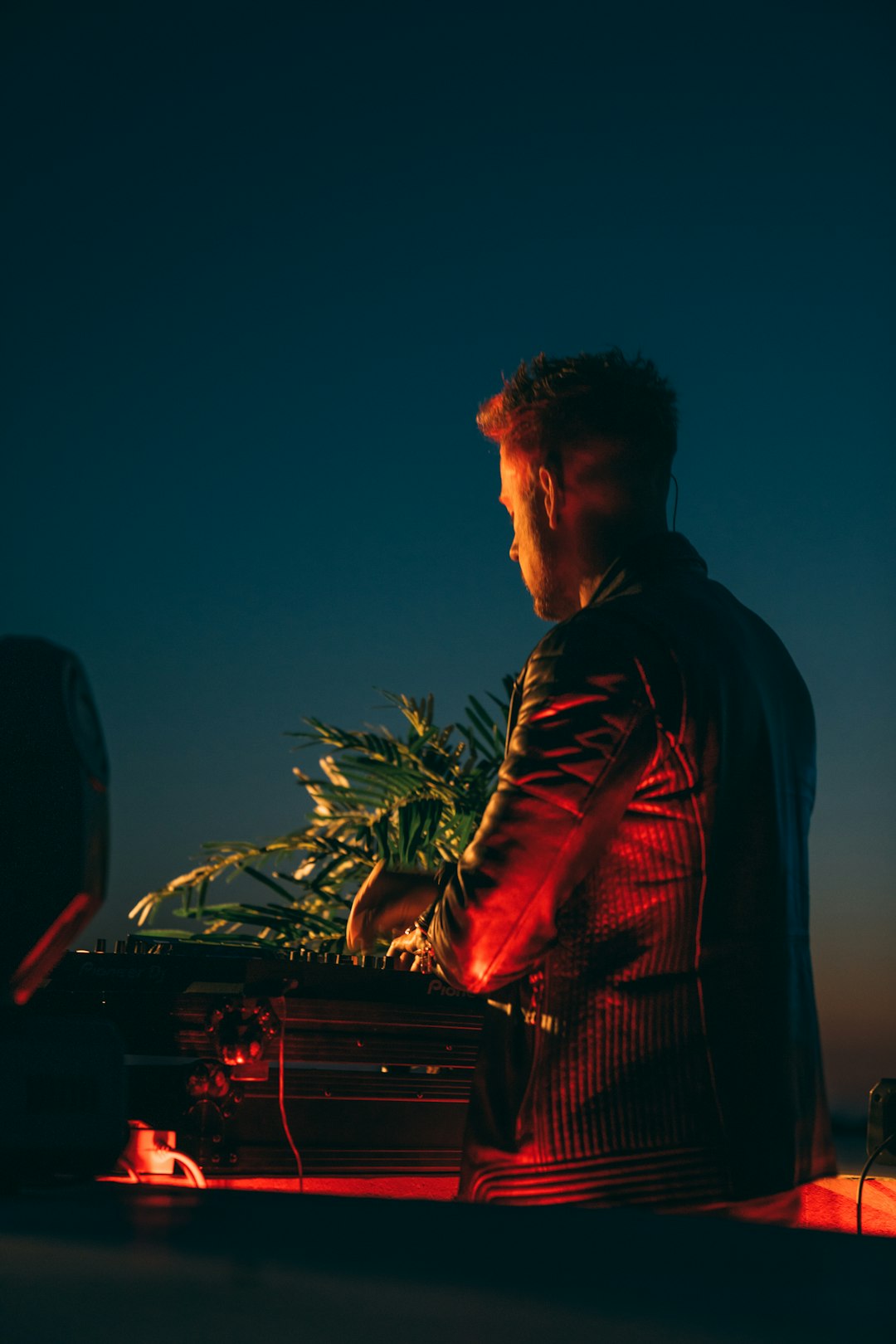 man in black jacket standing near green plant during daytime