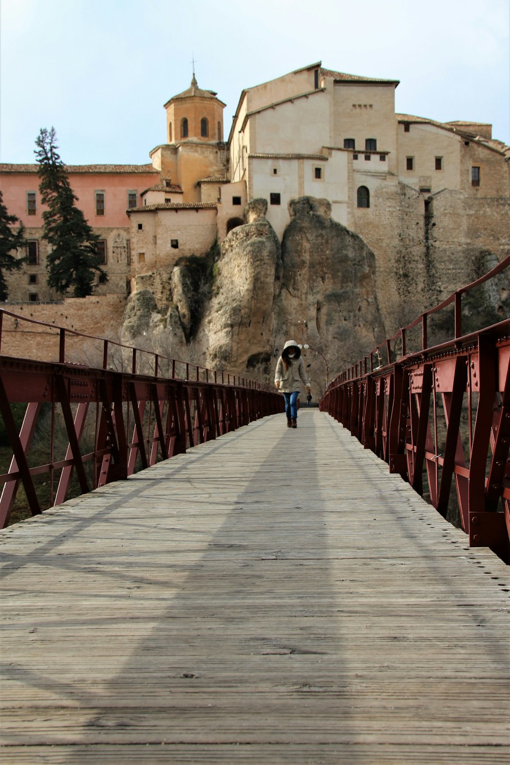 person walking on wooden bridge during daytime