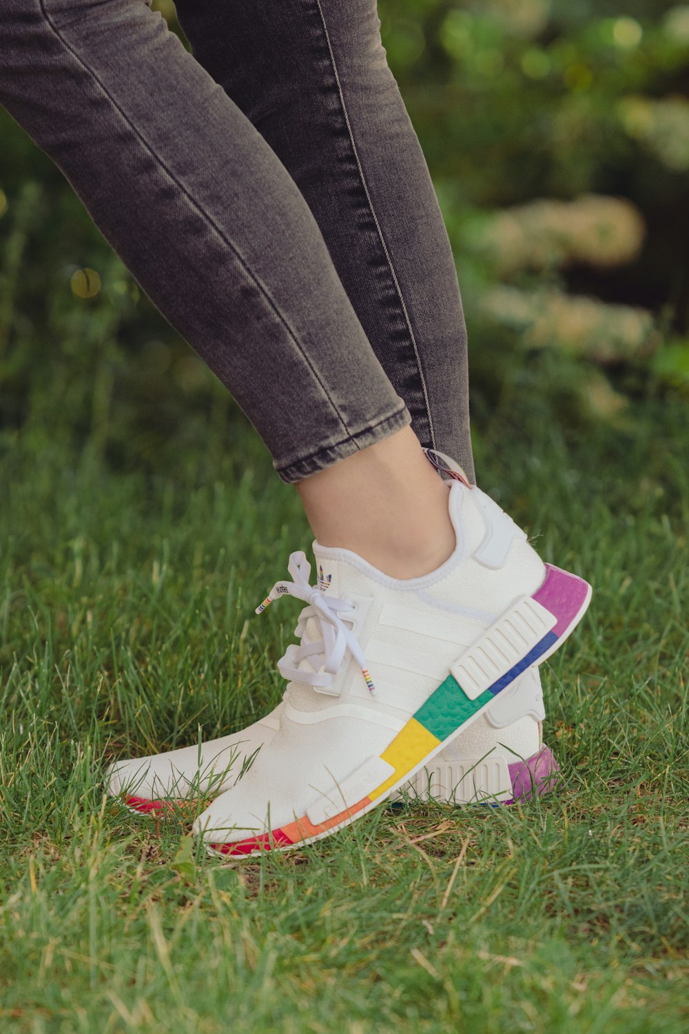 person in blue denim jeans and white and purple nike sneakers