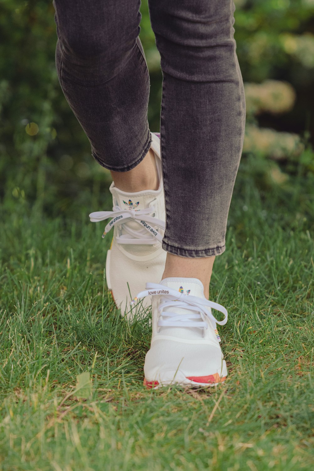 persona in jeans blu e scarpe da ginnastica bianche in piedi sul campo di  erba verde durante il giorno foto – Scarpa da ginnastica Immagine gratuita  su Unsplash