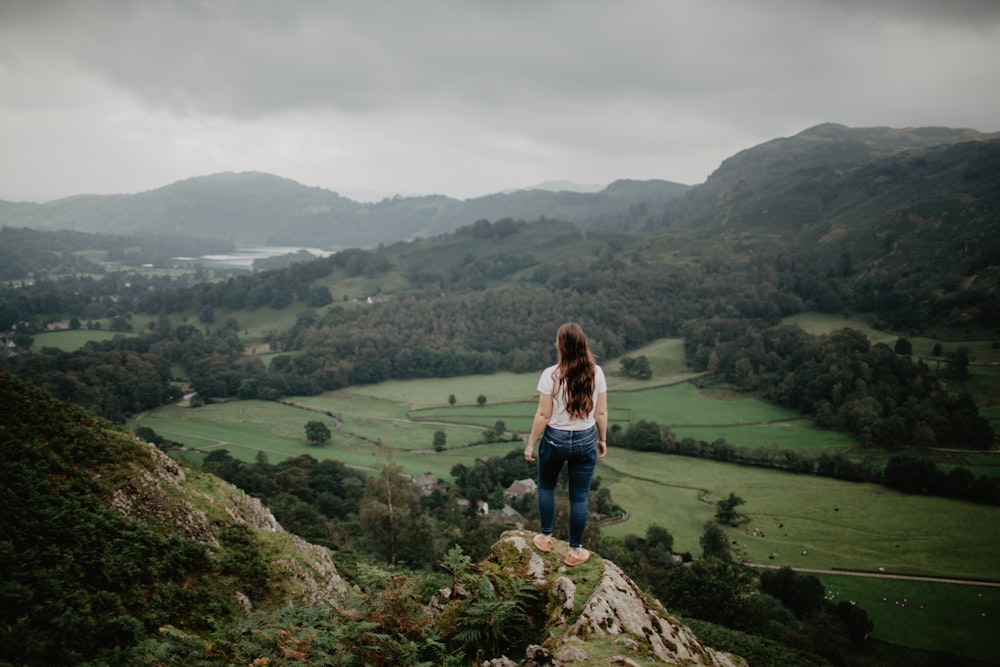 woman in blue denim jacket standing on green grass field during daytime