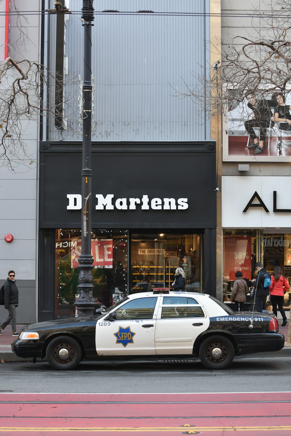 white and black police car parked beside black car during daytime