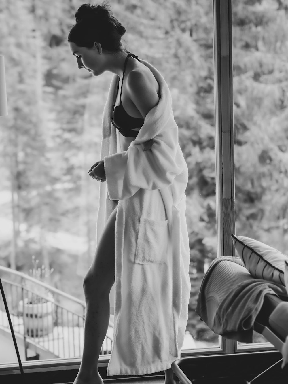 Mujer con vestido blanco de pie cerca de la ventana