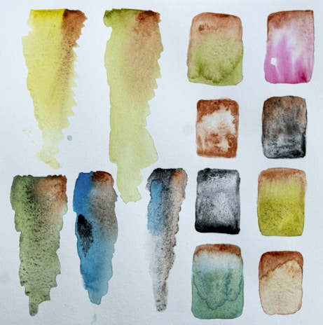 Watercolor swatches blending vibrant blues and greens with a textured paper background.