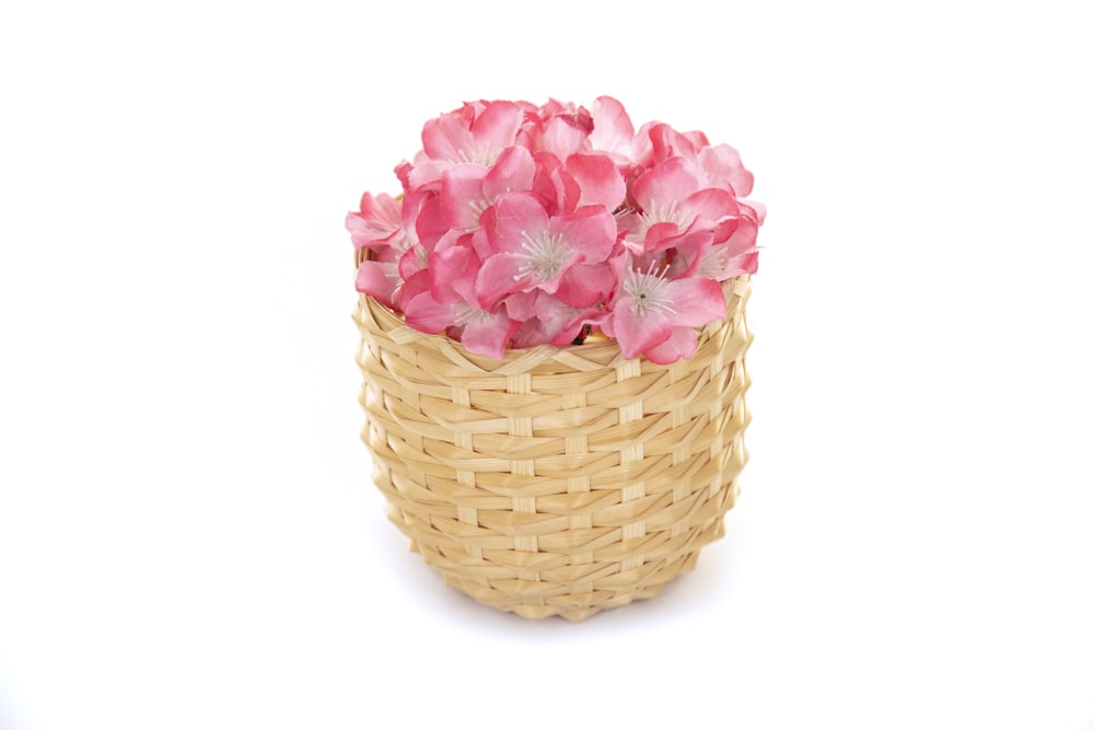 pink flowers in brown woven basket