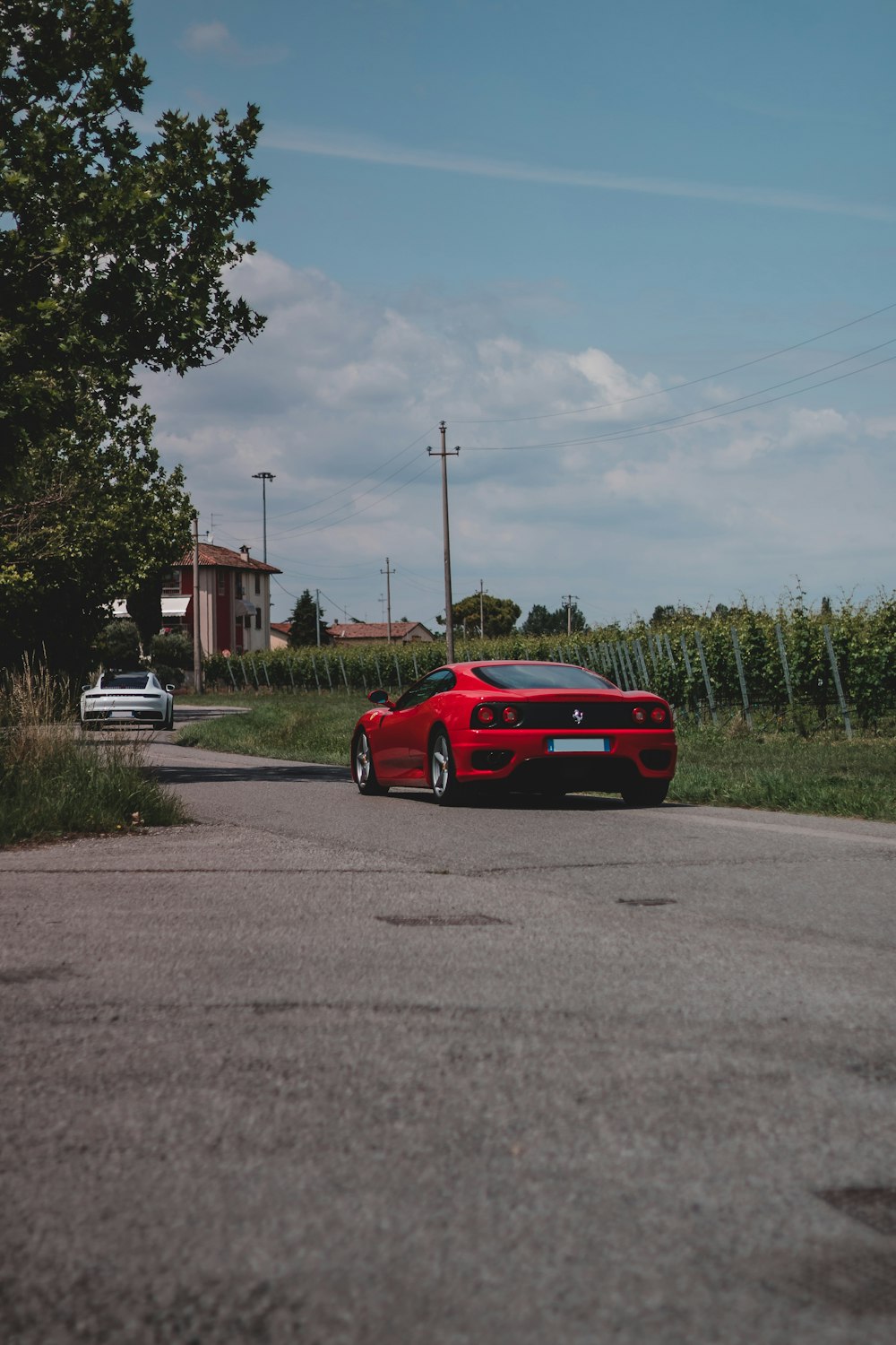 Ferrari coupé rossa su strada durante il giorno
