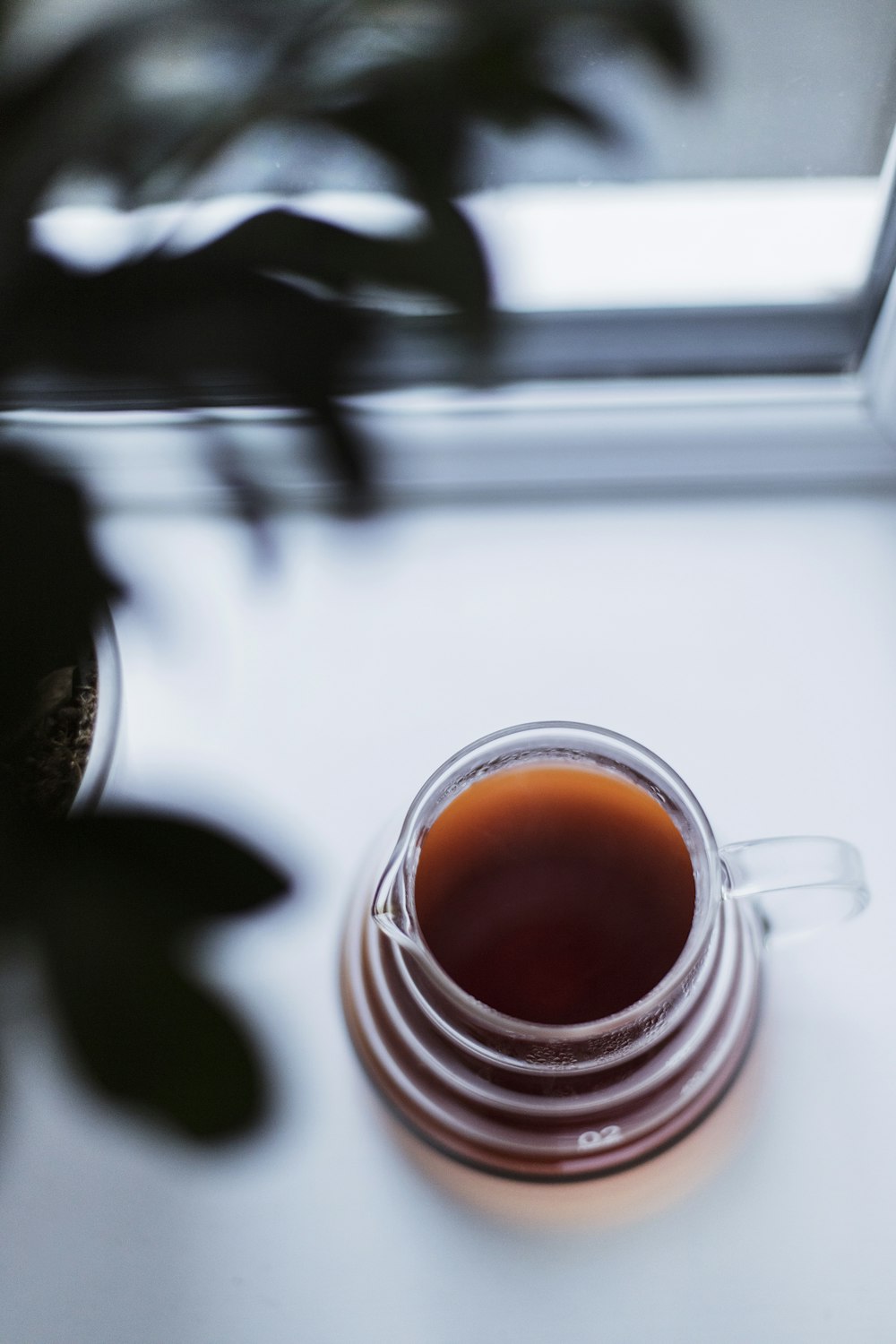 clear glass mug with brown liquid