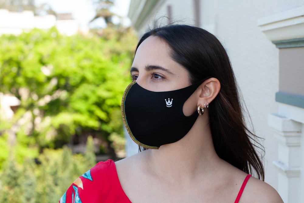woman in red and white shirt wearing black mask